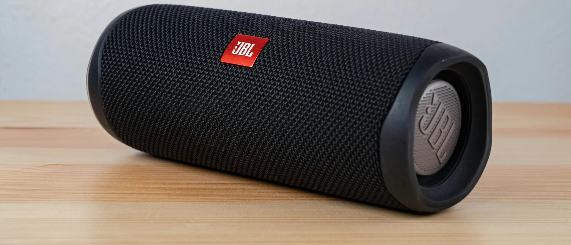 Enceinte Bluetooth portable posée sur un plateau de bois clair